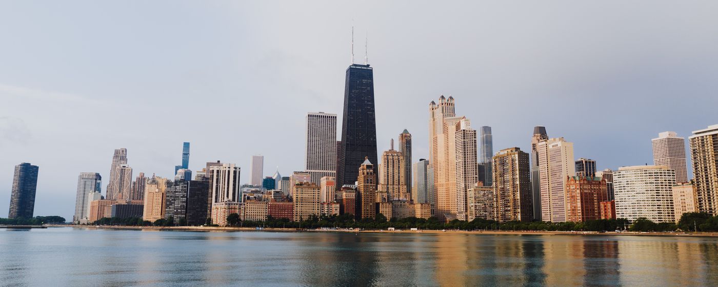 The Chicago skyline reflected in the waterfront under a clear sky