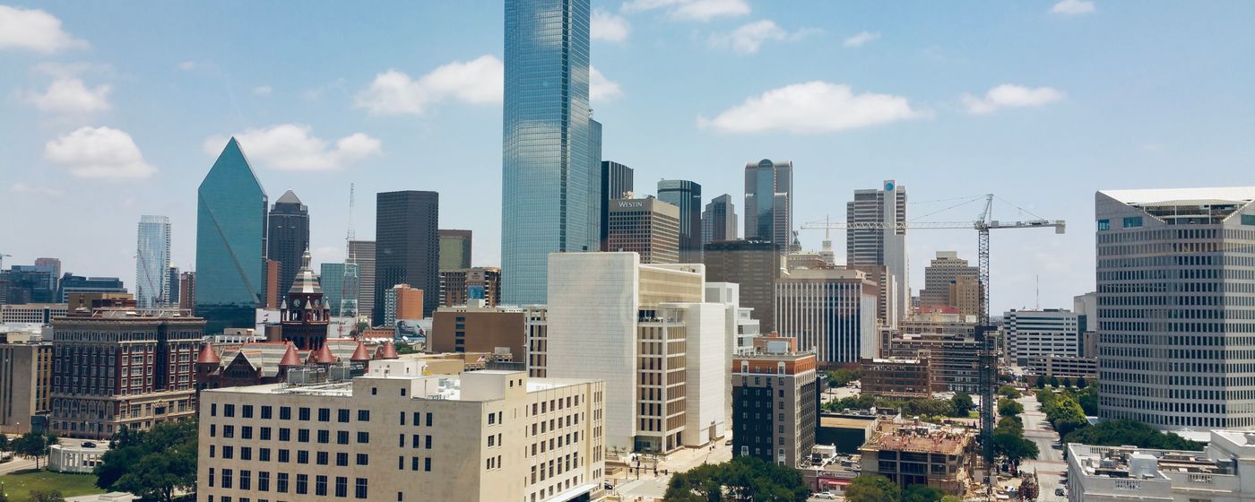 An aerial view of the Dallas skyline under a clear blue sky