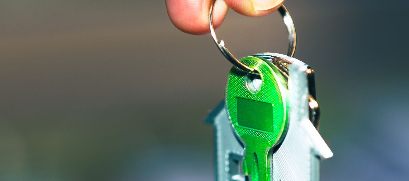 A hand holding house keys in sunlight