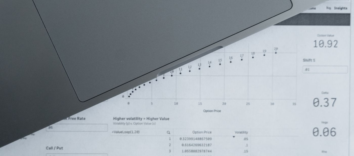Data sheets spread around a laptop, seen from above